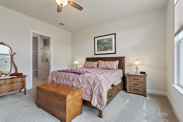 bedroom featuring ceiling fan, light carpet, and ensuite bath