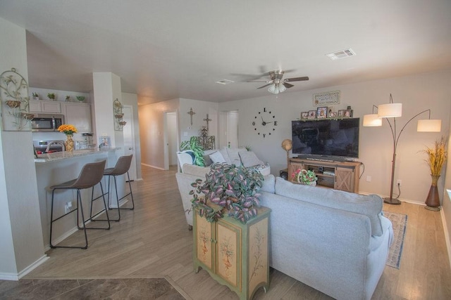 living room featuring ceiling fan and light hardwood / wood-style floors