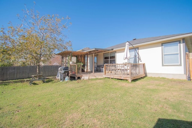 rear view of house with a wooden deck and a yard