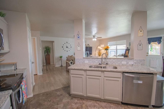 kitchen featuring sink, white cabinetry, plenty of natural light, stainless steel appliances, and light stone counters