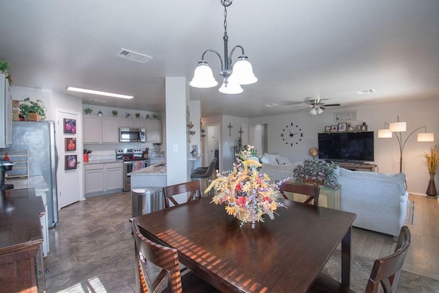 dining room with ceiling fan with notable chandelier