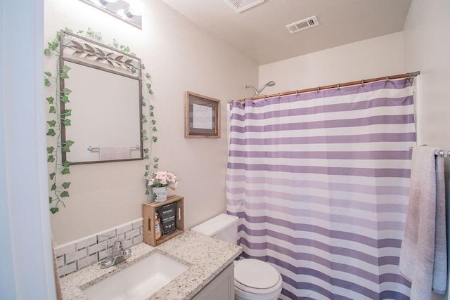 bathroom featuring vanity, curtained shower, and toilet