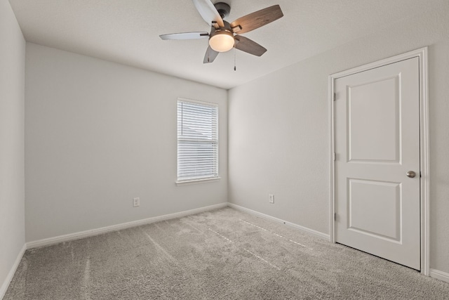 spare room with ceiling fan and light colored carpet