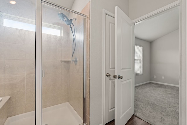 bathroom featuring vaulted ceiling, a wealth of natural light, and an enclosed shower