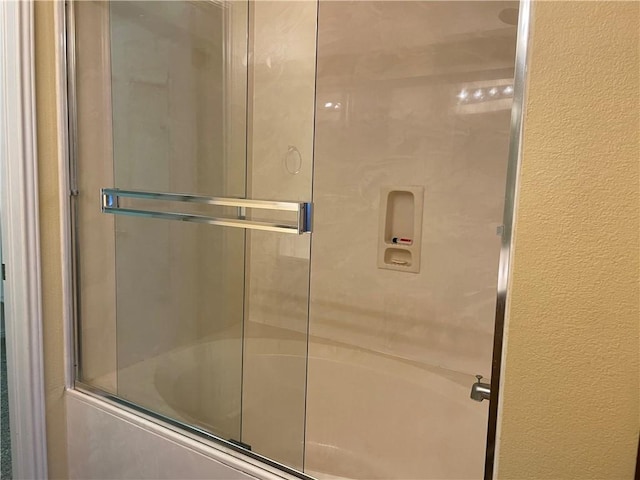 bathroom with shower / bath combination with glass door and elevator