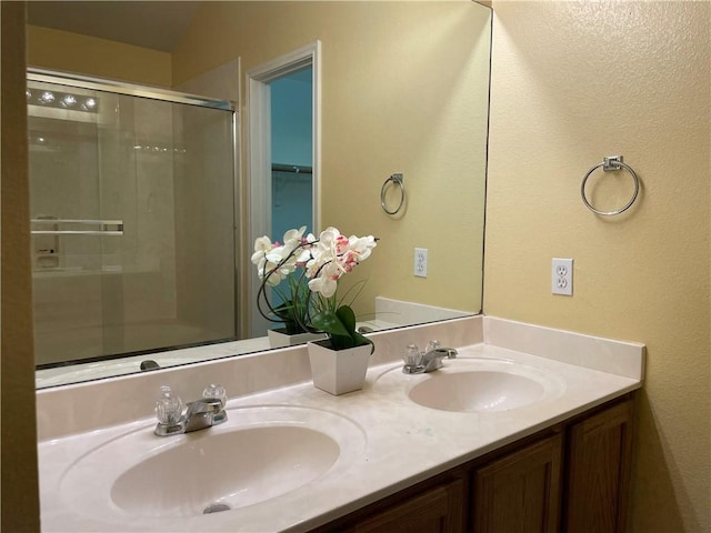 bathroom with vanity and a shower with shower door