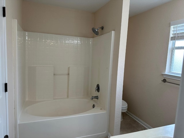 bathroom featuring  shower combination, tile patterned floors, and toilet