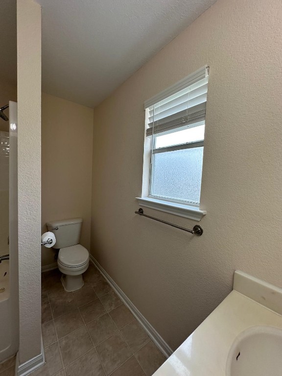 bathroom with vanity, tile patterned flooring, a shower, and toilet