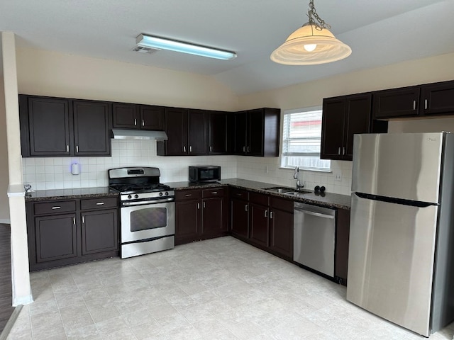 kitchen featuring lofted ceiling, sink, hanging light fixtures, appliances with stainless steel finishes, and backsplash