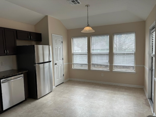 kitchen featuring backsplash, lofted ceiling, stainless steel appliances, and a wealth of natural light