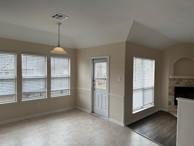 entryway with lofted ceiling and a fireplace