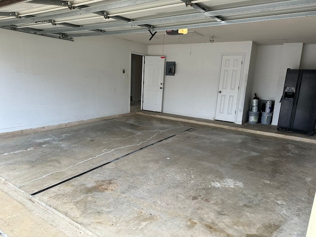 garage with a garage door opener, black fridge with ice dispenser, and electric panel