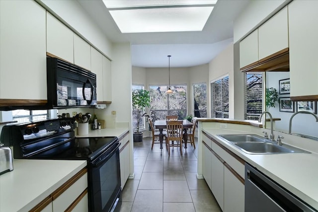 kitchen with black appliances, a sink, light countertops, and white cabinets