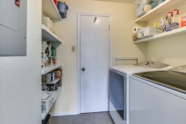 laundry room with dark tile patterned floors and washer and dryer