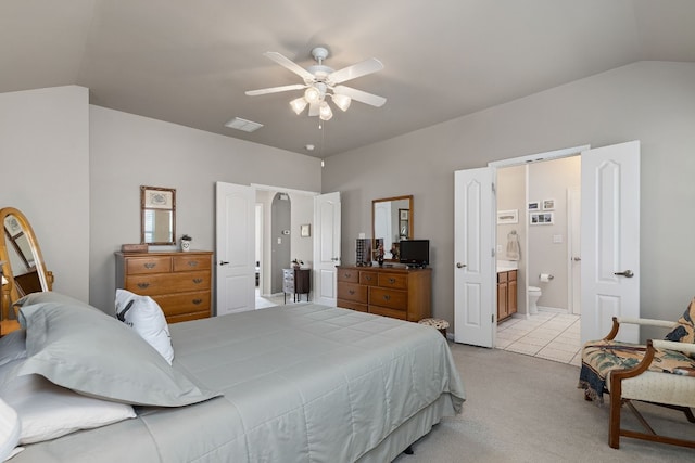 carpeted bedroom with connected bathroom, vaulted ceiling, and ceiling fan