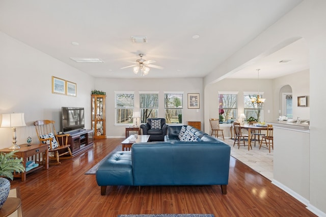 living room featuring ceiling fan with notable chandelier and wood-type flooring