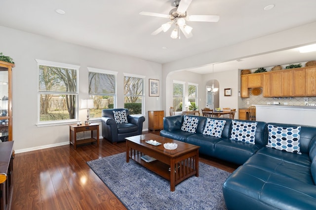 living room with dark wood-type flooring and ceiling fan