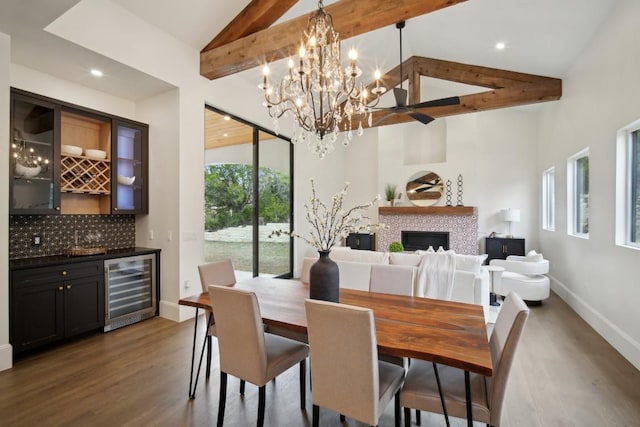 dining space featuring dark hardwood / wood-style floors, a tile fireplace, beverage cooler, and beamed ceiling