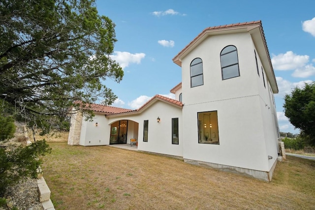 rear view of property featuring a yard and a patio area