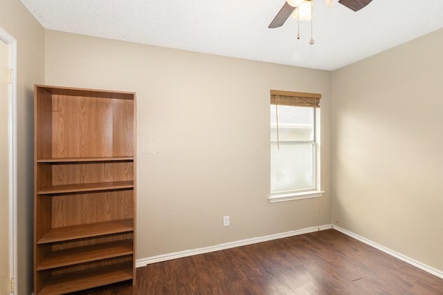 empty room featuring dark wood-type flooring and ceiling fan