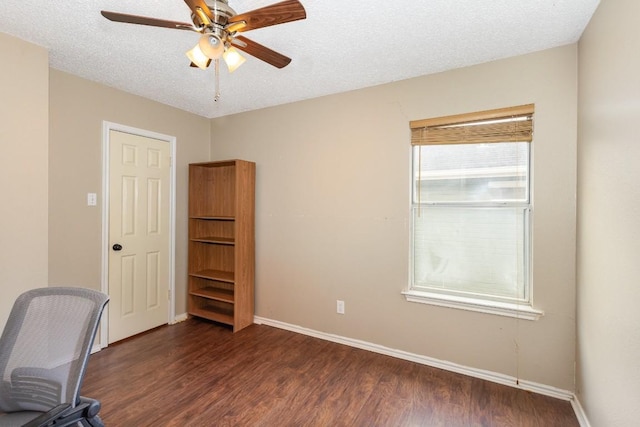 unfurnished office featuring dark wood-type flooring, ceiling fan, and a textured ceiling