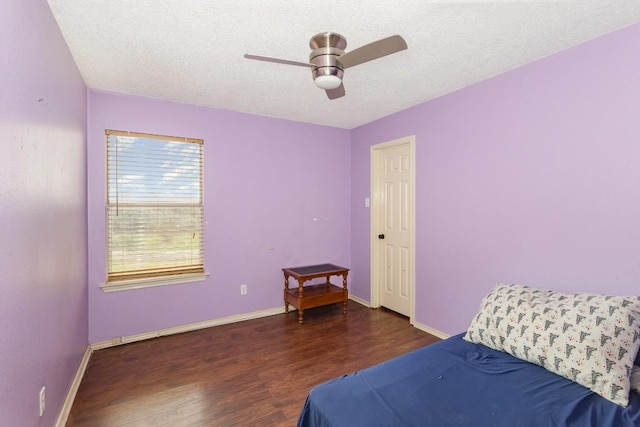 bedroom with ceiling fan, dark hardwood / wood-style floors, and a textured ceiling