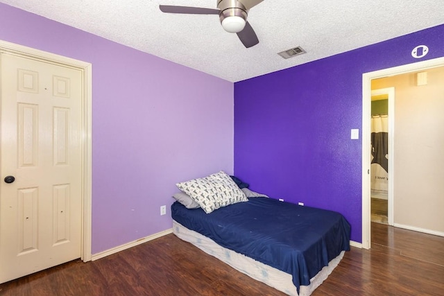 bedroom featuring ceiling fan, dark hardwood / wood-style flooring, and a textured ceiling