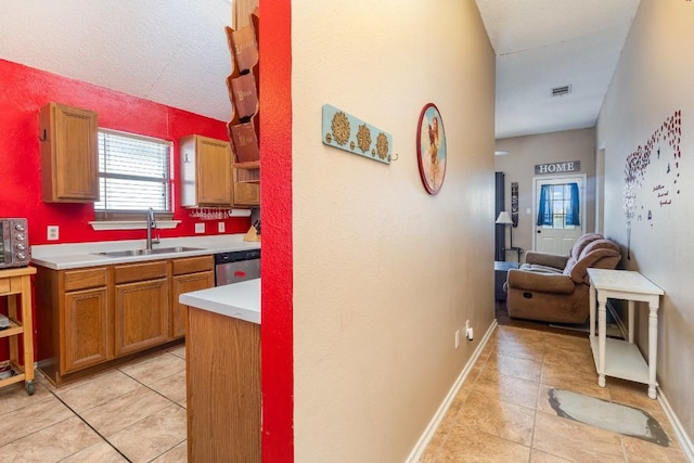 kitchen with sink, dishwasher, and light tile patterned flooring