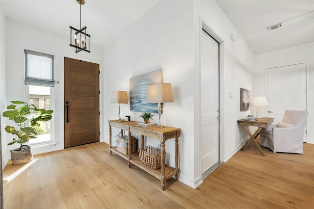 entrance foyer with a notable chandelier and light wood-type flooring