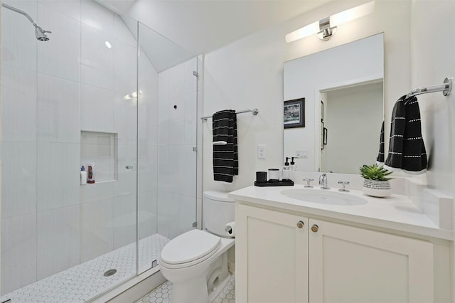 bathroom featuring vanity, toilet, and a shower with door