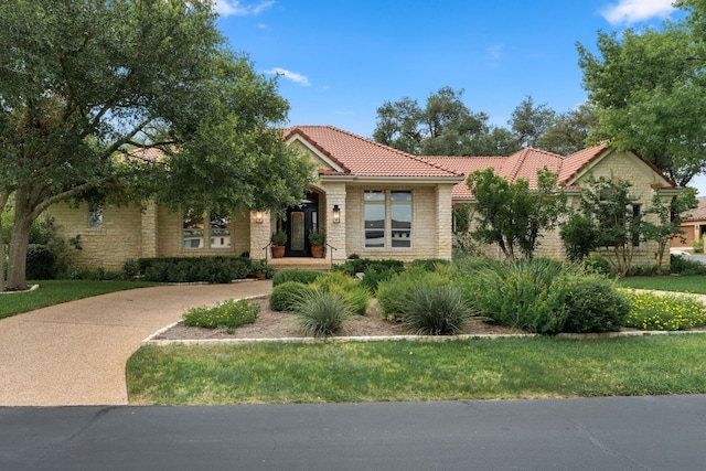 mediterranean / spanish home with a front yard