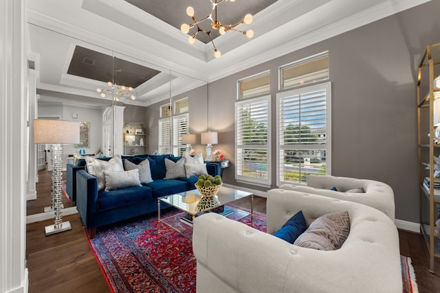 living room with wood-type flooring, ornamental molding, a chandelier, and a tray ceiling