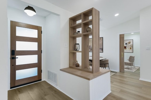 mudroom featuring vaulted ceiling and light hardwood / wood-style floors