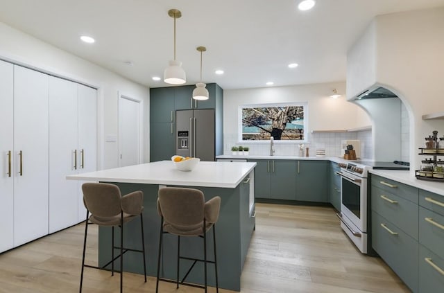 kitchen featuring high end fridge, tasteful backsplash, a center island, light hardwood / wood-style flooring, and electric stove