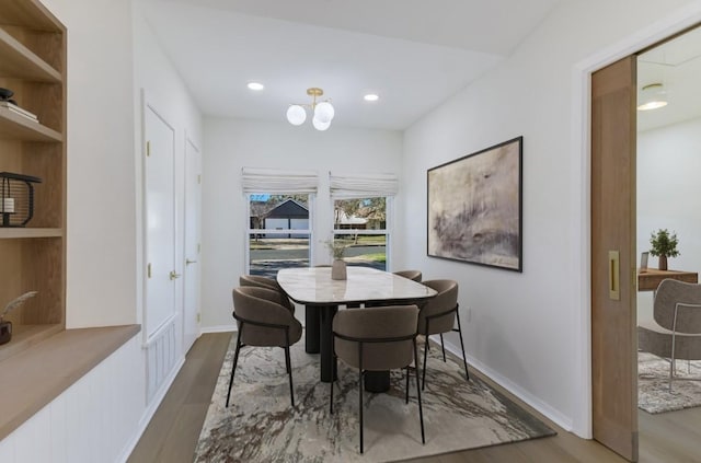 dining room with hardwood / wood-style flooring and an inviting chandelier