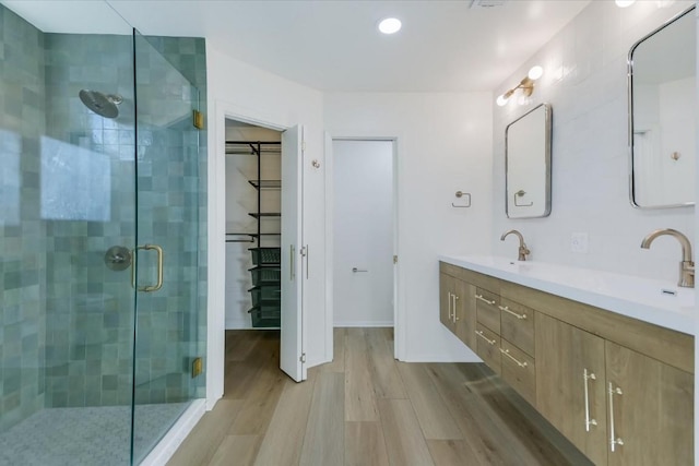 bathroom featuring vanity, hardwood / wood-style floors, and a shower with door