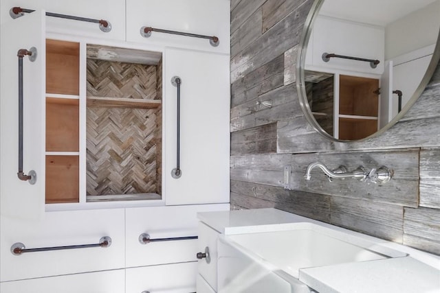 bathroom featuring sink and wooden walls