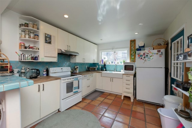 kitchen featuring sink, white appliances, tile counters, and white cabinets