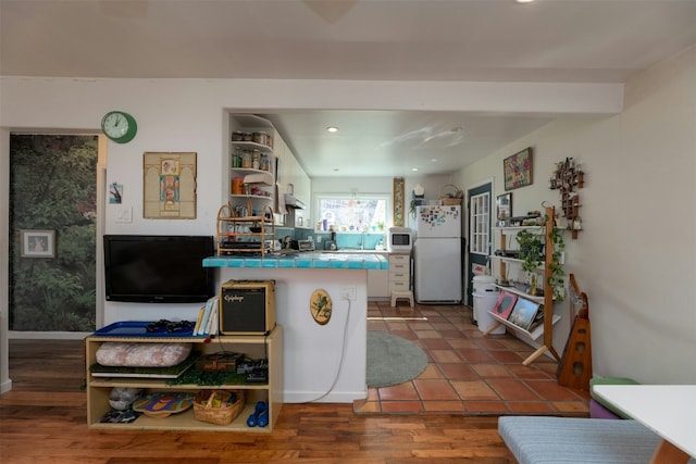 kitchen featuring hardwood / wood-style floors, tile counters, and white appliances