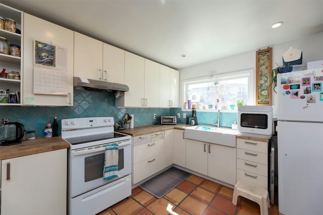 kitchen with tasteful backsplash, sink, white cabinets, tile patterned flooring, and white appliances