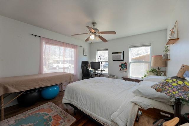 bedroom featuring multiple windows, dark hardwood / wood-style floors, a wall mounted air conditioner, and ceiling fan