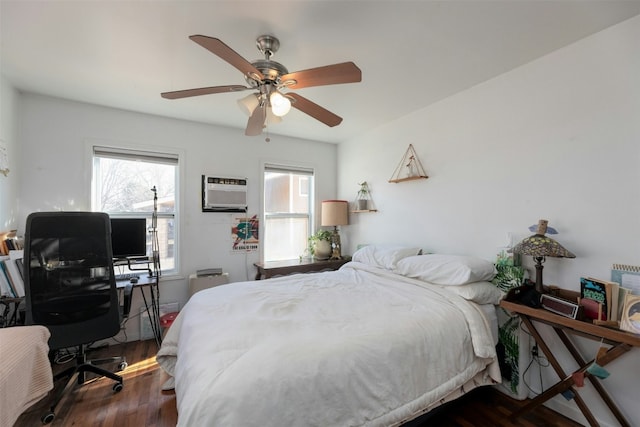 bedroom featuring ceiling fan, dark hardwood / wood-style floors, and a wall unit AC