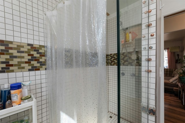 bathroom featuring tiled shower and tile walls