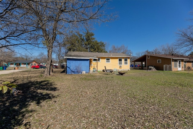 back of property featuring a lawn and a carport