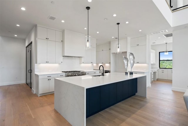 6101 Adhara Pass, Austin, TX 78730 - kitchen with light wood-style floors, a large island, white cabinets, light countertops, and recessed lighting