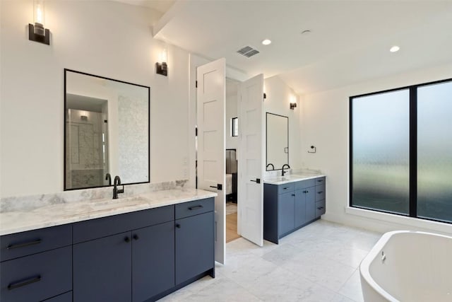6101 Adhara Pass, Austin, TX 78730 - bathroom with two vanities, a freestanding tub, marble finish flooring, and recessed lighting