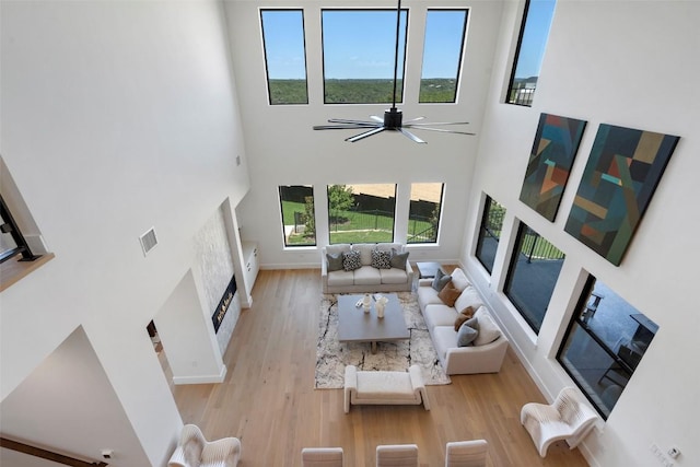 6101 Adhara Pass, Austin, TX 78730 - living area featuring a high ceiling, a fireplace, light wood finished floors, and a ceiling fan