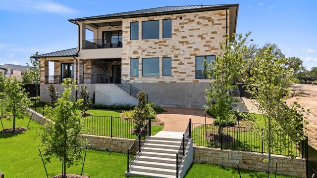 6101 Adhara Pass, Austin, TX 78730 - modern home with a balcony, stairway, a standing seam roof, and a fenced backyard