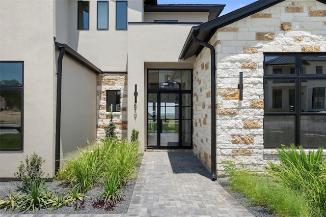 6101 Adhara Pass, Austin, TX 78730 - view of exterior entry featuring stone siding, stucco siding, and french doors