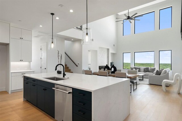 6101 Adhara Pass, Austin, TX 78730 - kitchen with light wood-style floors, white cabinets, open floor plan, healthy amount of natural light, and recessed lighting